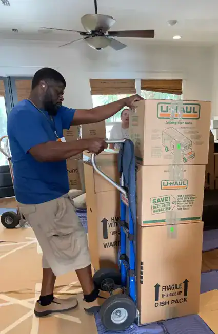 a member of It's Your Move moving boxes on a trolley cart in Tallahassee, FL